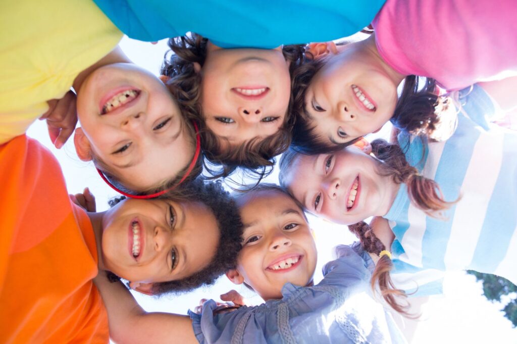 Groupe d'enfant bras dessus bras dessous en forme de cercle.