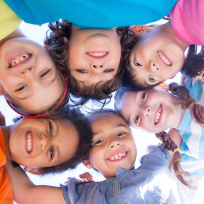 Groupe d'enfant bras dessus bras dessous en forme de cercle.